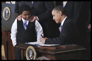 President Barack Obama signs the healthcare reform bill Tuesday in the White House as 11-year-old Marcellus Owens looks on. CHARLES DHARAPAK / AP