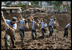 Oct 11: Filipino police dig for bodies in La Trinidad, Philippines, after Typhoon Parma.